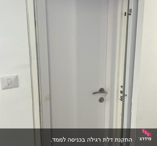 דלת לבנה עם ידית כסופה וקיר לבן